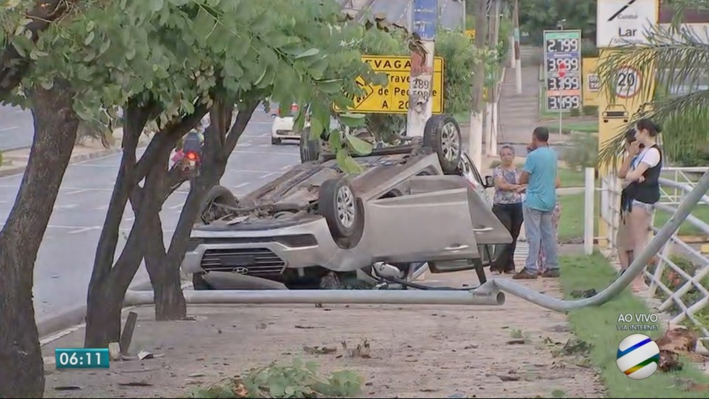 Carro capota, derruba placa, árvores e atinge grade de loja em avenida